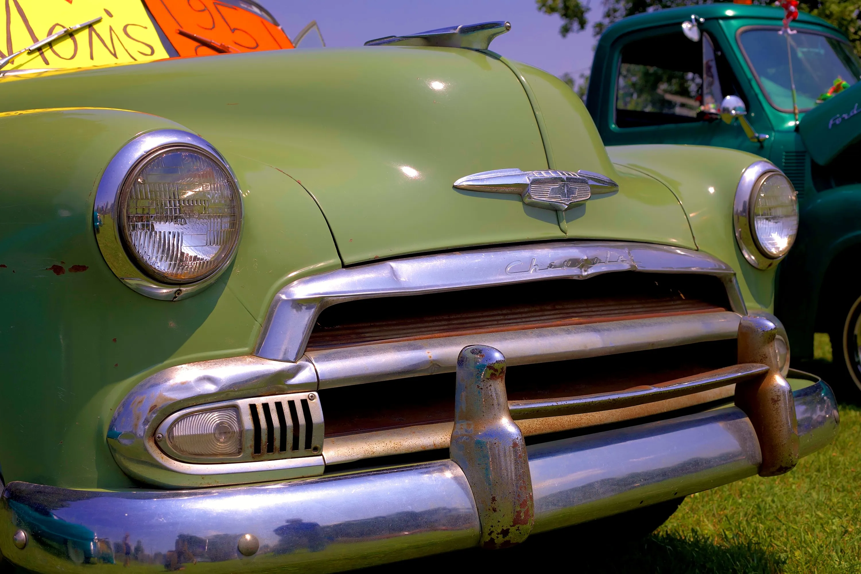 Period character — a low portrait preserves the patina, sculpted bodywork and brightwork of a vintage Chevrolet.